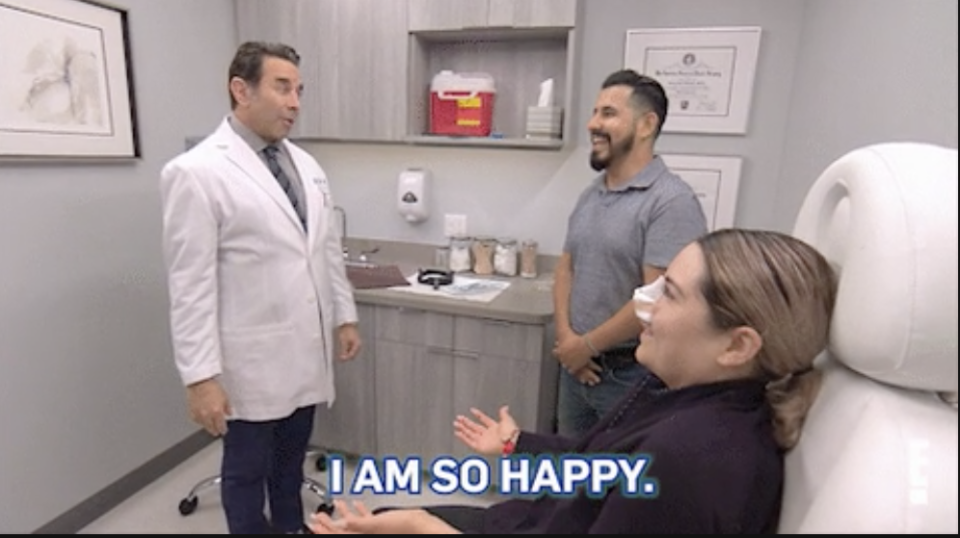 a woman in a surgeon's office saying, "i am so happy."