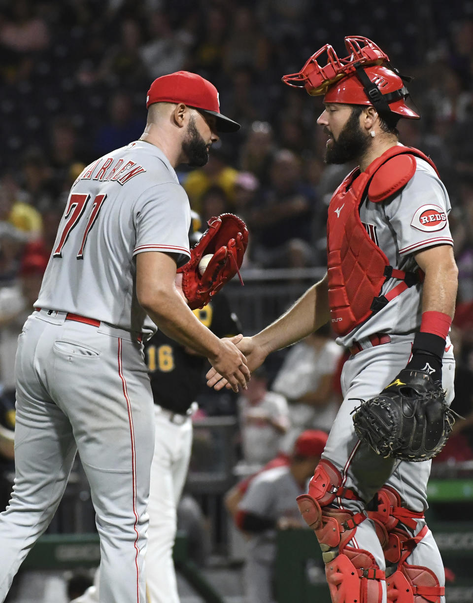 Cincinnati Reds relief pitcher Art Warren (77) and catcher Austin Romine greet each other after a baseball game against the Pittsburgh Pirates, Saturday, Aug. 20, 2022, in Pittsburgh. (AP Photo/Philip G. Pavely)