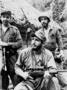FILE - In this March 14, 1957 file photo, Fidel Castro, the young anti-Batista guerrilla leader, center, stands with his brother Raul Castro, front, and Camilo Cienfuegos, while operating in the mountains of eastern Cuba. For most of his life, Raul Castro played second-string to his brother, but for the past decade, it’s Raul who's been the face of communist Cuba. On Friday, April 16, 2021, Raul Castro formally announced he'd step down as head of the Communist Party, leaving Cuba without a Castro in an official position of command for the first time in more than six decades. (AP Photo/Andrew St. George, File)