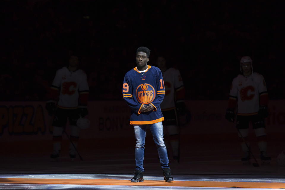 Canadian soccer player Alphonso Davies waits to drop the puck during a ceremonial faceoff before the Edmonton Oilers and Calgary Flames played an NHL hockey game in Edmonton, Alberta, Friday, Dec. 27, 2019. (Darryl Dyck/The Canadian Press via AP)