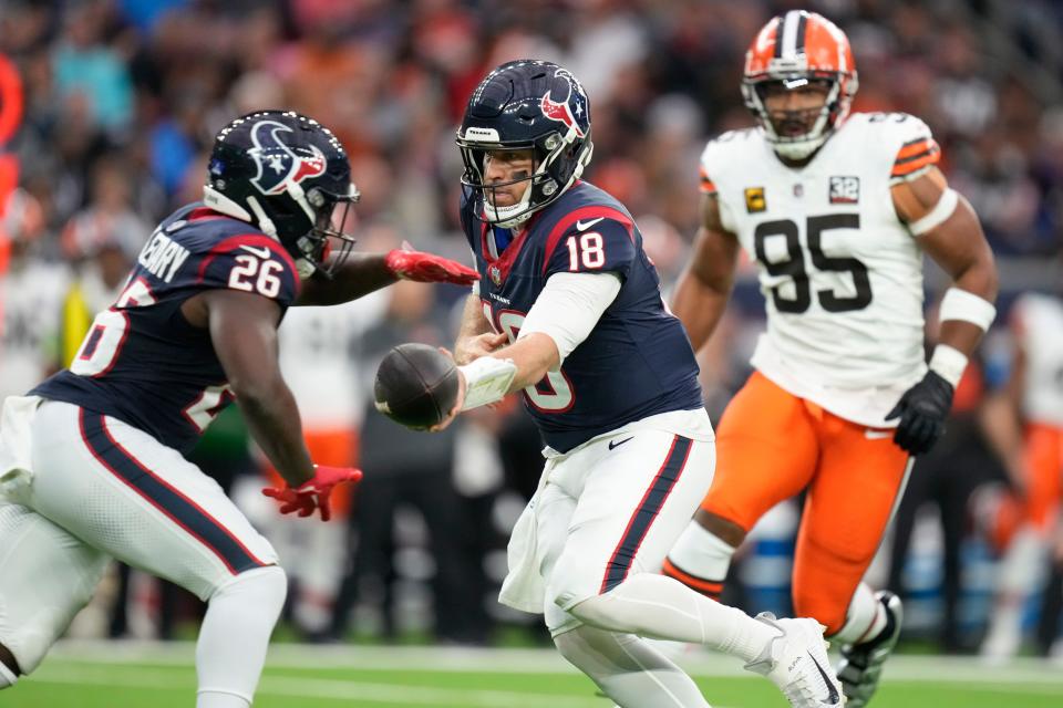 Houston Texans quarterback Case Keenum (18) hands off the ball to running back Devin Singletary (26) as Cleveland Browns defensive end Myles Garrett (95) pressures Dec. 24 in Houston.