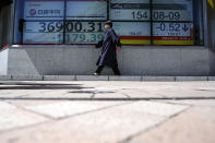 A person walks in front of an electronic stock board showing Japan's Nikkei 225 index at a securities firm Friday, April 19, 2024, in Tokyo. (AP Photo/Eugene Hoshiko)