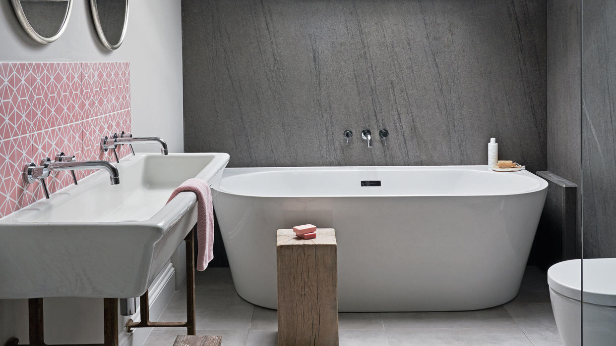  gray bathroom with white tub and large sink 