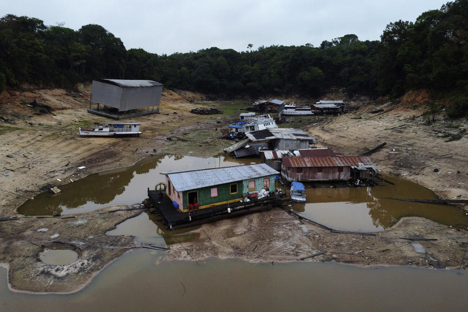 Boats and houseboats are stuck in a dry area of the Negro River during a drought in Manaus, Amazonas state, Brazil, Monday, Oct. 16, 2023. The Amazon’s second largest tributary on Monday reached its lowest level since official measurements began near Manaus more than 120 years ago. (AP Photo/Edmar Barros)