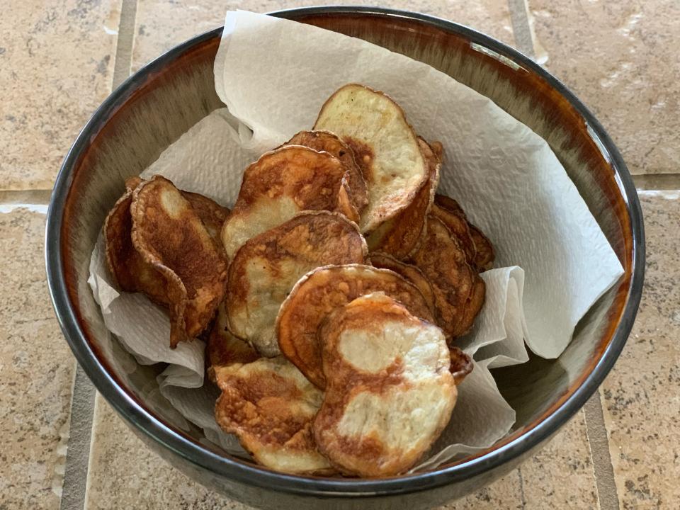 Cooked potato chips in a brown/grey bowl