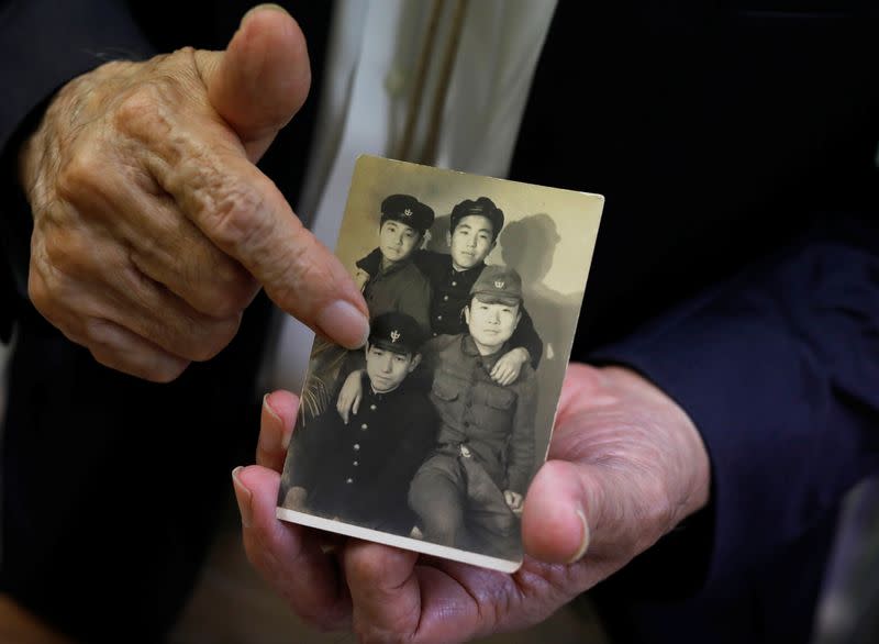 Terumi Tanaka shows his photo during an interview with Reuters in Tokyo