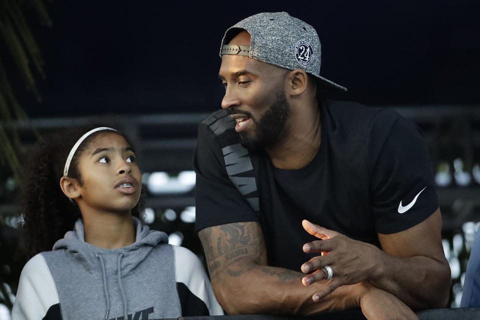 FILE - In this July 26, 2018 file photo former Los Angeles Laker Kobe Bryant and his daughter Gianna watch the U.S. national championships swimming meet in Irvine, Calif. Bryant, the 18-time NBA All-Star who won five championships and became one of the greatest basketball players of his generation during a 20-year career with the Los Angeles Lakers, died in a helicopter crash Sunday, Jan. 26, 2020. Gianna also died in the crash. (AP Photo/Chris Carlson, file)