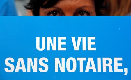 A notary holds a placard reading "A life without notaries" as she demonstrates during their first-ever public protest against a plan to chip away at rules shielding them from competition in Marseille September 17, 2014. REUTERS/Jean-Paul Pelissier