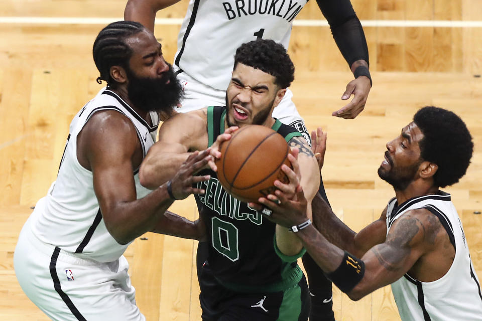 BOSTON, MA - MAY 28:  Jayson Tatum #0 of the Boston Celtics drives to the basket while guarded by James Harden #13 and Kyrie Irving #11 of the Brooklyn Nets during Game Three of the Eastern Conference first round series at TD Garden on May 28, 2021 in Boston, Massachusetts. NOTE TO USER: User expressly acknowledges and agrees that, by downloading and or using this photograph, User is consenting to the terms and conditions of the Getty Images License Agreement. (Photo by Adam Glanzman/Getty Images)