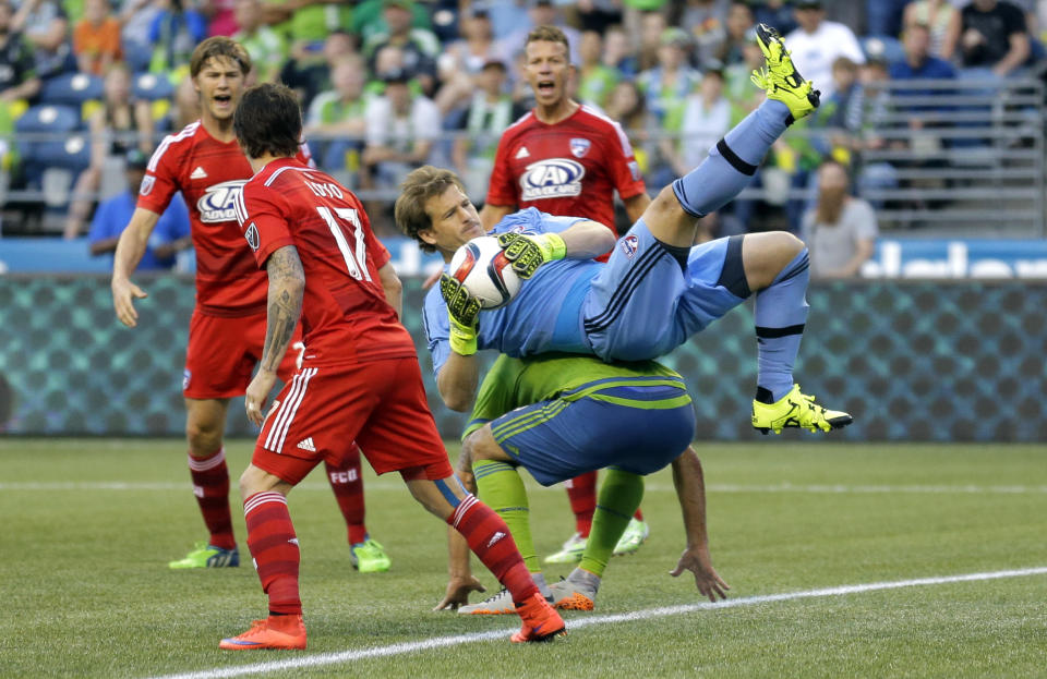 FC Dallas goalkeeper Dan Kennedy lands on Seattle Sounders forward Clint Dempsey during an MLS soccer match, Saturday, June 13, 2015, in Seattle. (AP Photo/Ted S. Warren)