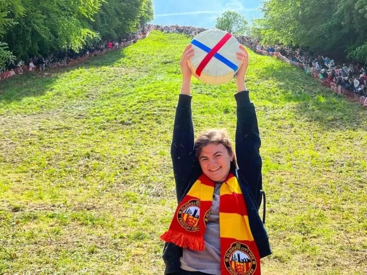 Delaney Irving holds her trophy high after winning Race 3 of the 2023 Cooper's Hill Cheese-Rolling & Wake. (Submitted by Delaney Irving - image credit)