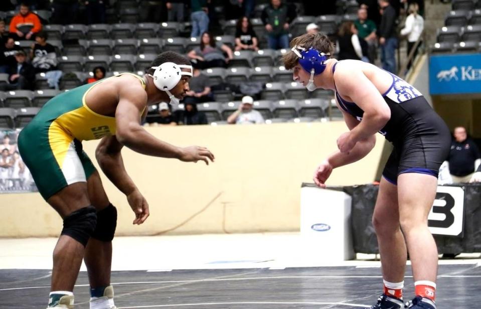 Bryan Station’s Jahvon Frazier, left, squares off against Paducah Tilghman’s Jack James in the 215 class finals at the boys/coed KHSAA State Wrestling Championships at the Kentucky Horse Park’s Alltech Arena on Friday. Jared Peck/jpeck@herald-leader.com