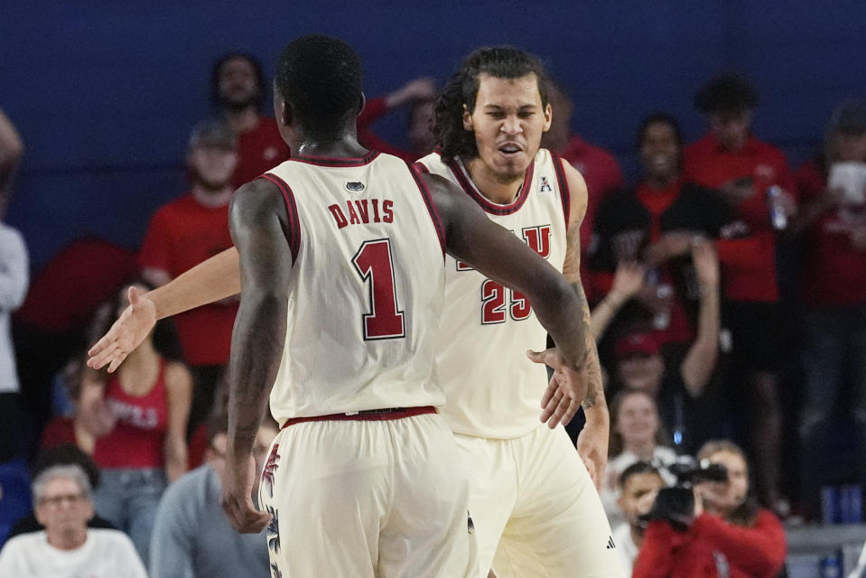 Florida Atlantic forward Tre Carroll (25) and guard Johnell Davis (1) celebrate during the first half of an NCAA college basketball game against UAB, Sunday, Jan. 14, 2024, in Boca Raton, Fla. (AP Photo/Marta Lavandier)