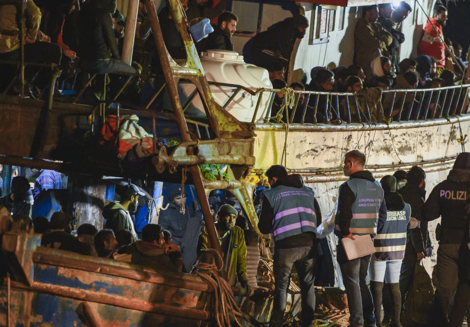 Police check a fishing boat with some 500 migrants in the southern Italian port of Crotone, early Saturday, March 11, 2023. The Italian coast guard was responding to three smugglers boats carrying more than 1,300 migrants “in danger” off Italy’s southern coast, officials said Friday. Three small coast guard boats were rescuing a boat with 500 migrants about 700 miles off the Calabria region, which forms the toe of the Italian boot. (AP Photo/Valeria Ferraro)