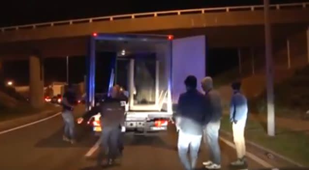 The migrants do not get very far when the police open the truck doors to find them hiding. Photo: YouTube