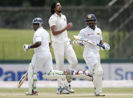 Sri Lanka's Rangana Herath (L) and Kusal Perera (R) run between wickets next to India's Ishant Sharma during the third day of their third and final test cricket match in Colombo, August 30, 2015. REUTERS/Dinuka Liyanawatte