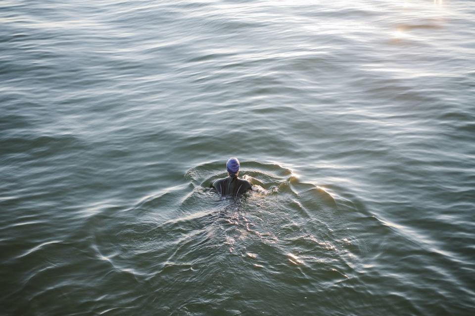 انگلستان، کنت، خلیج هرنه، شناگر زن در آب های آزاد که به سختی در دریا تمرین می کنند