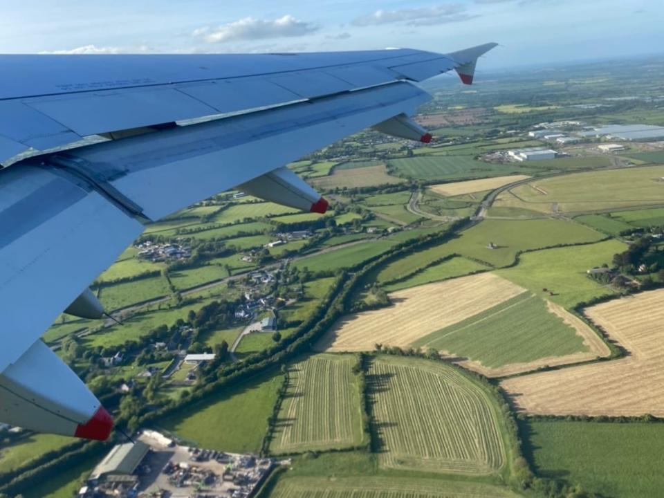 view from a plane flying over fields in ireland on a clear day