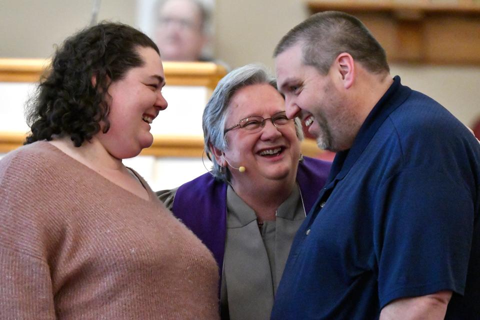 Reverend Linda Barnes Popham, center, welcomes new members Tiffany Keranen, left and Kevin Keranen during the Sunday sermon of the Fern Creek Baptist Church, Sunday, March 5 2023 in Louisville Ky.