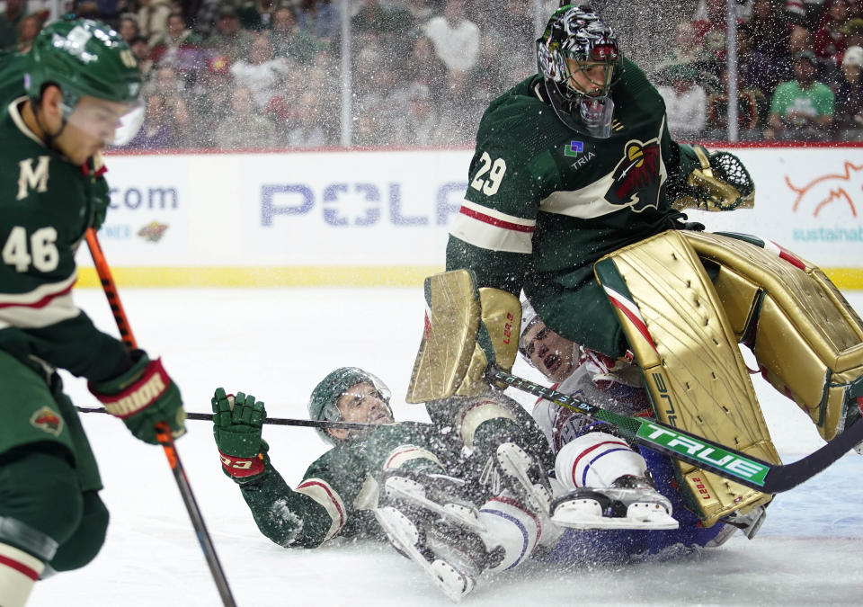 Minnesota Wild center Steven Fogarty (28), middle left, and Montreal Canadiens left wing Juraj Slafkovsky (20), middle right, collide into Minnesota Wild goaltender Marc-Andre Fleury (29), right, during the second period of an NHL hockey game Tuesday, Nov. 1, 2022, in St. Paul, Minn. (AP Photo/Abbie Parr)