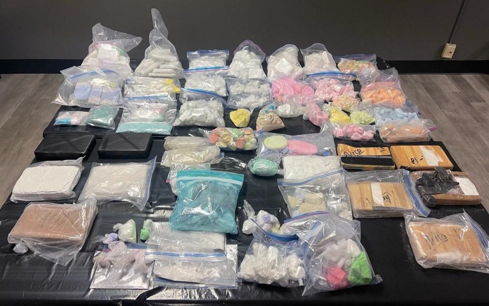 Many bags of drugs are laid out on a table