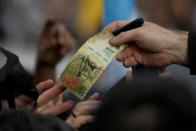 Presidential hopeful of the Liberty Advances coalition Javier Milei hands back a bill he autographed for a supporter during a campaign event in La Plata, Argentina, Tuesday, Sept. 12, 2023. General elections are set in Argentina for Oct. 22. (AP Photo/Natacha Pisarenko)