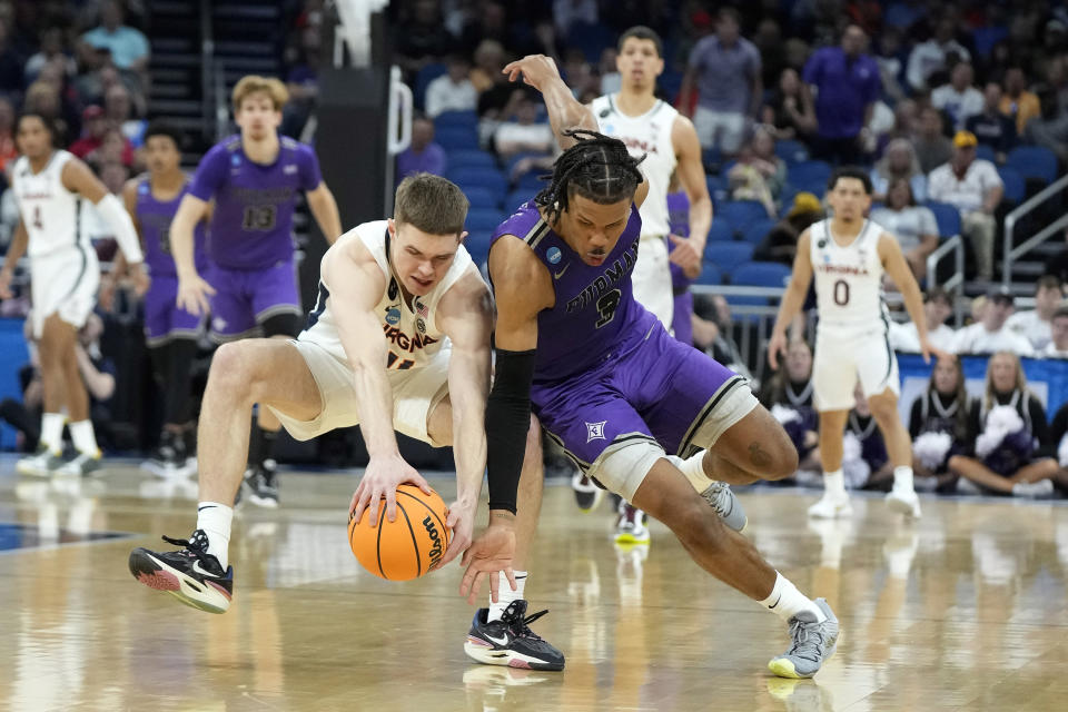 Virginia guard Isaac McKneely (11) and Furman guard Mike Bothwell (3) collide chasing a loose ball during the first half of a first-round college basketball game in the NCAA Tournament Thursday, March 16, 2023, in Orlando, Fla. (AP Photo/Chris O'Meara)