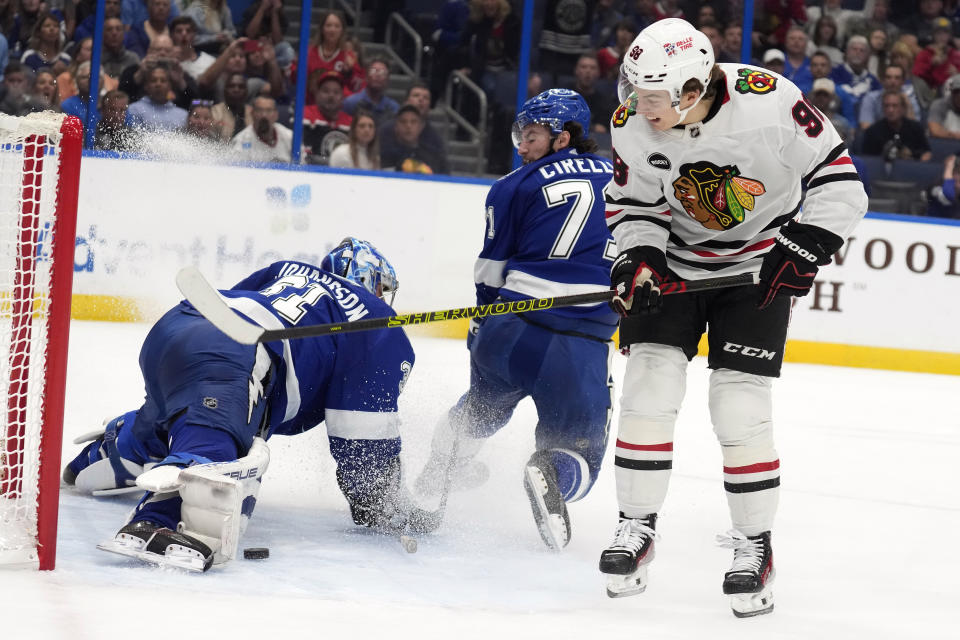 Chicago Blackhawks center Connor Bedard (98) scores past Tampa Bay Lightning goaltender Jonas Johansson (31) and center Anthony Cirelli (71) during the first period of an NHL hockey game Thursday, Nov. 9, 2023, in Tampa, Fla. (AP Photo/Chris O'Meara)