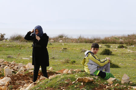 Syrian refugees wait on a roadside after Turkish police prevented them from sailing off to the Greek island of Farmakonisi by dinghies, near a beach in the western Turkish coastal town of Didim, Turkey March 9, 2016. REUTERS/Umit Bektas