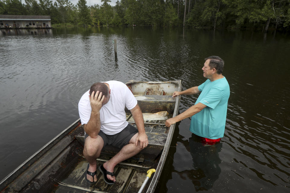 Stephen Gilbert, left, and his father-in-law sit in front of their flooded property on Friday, Sept. 20, 2019, in the Mauriceville, Texas, area. Floodwaters are starting to recede in most of the Houston area after the remnants of Tropical Storm Imelda flooded parts of Texas. "I'm on my third house," said Gilbert, who lives behind his father-in-law. "I wouldn't go anywhere else in the world," he said. "All we have is family anyway." ( Jon Shapley/Houston Chronicle via AP)