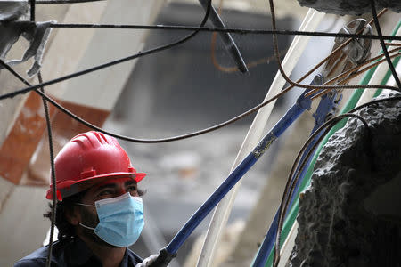 A rescue worker cuts steel wires as he searches for bodies still trapped under mounds of debris in Raqqa, Syria April 9, 2018. Picture taken April 9, 2018. REUTERS/Aboud Hamam