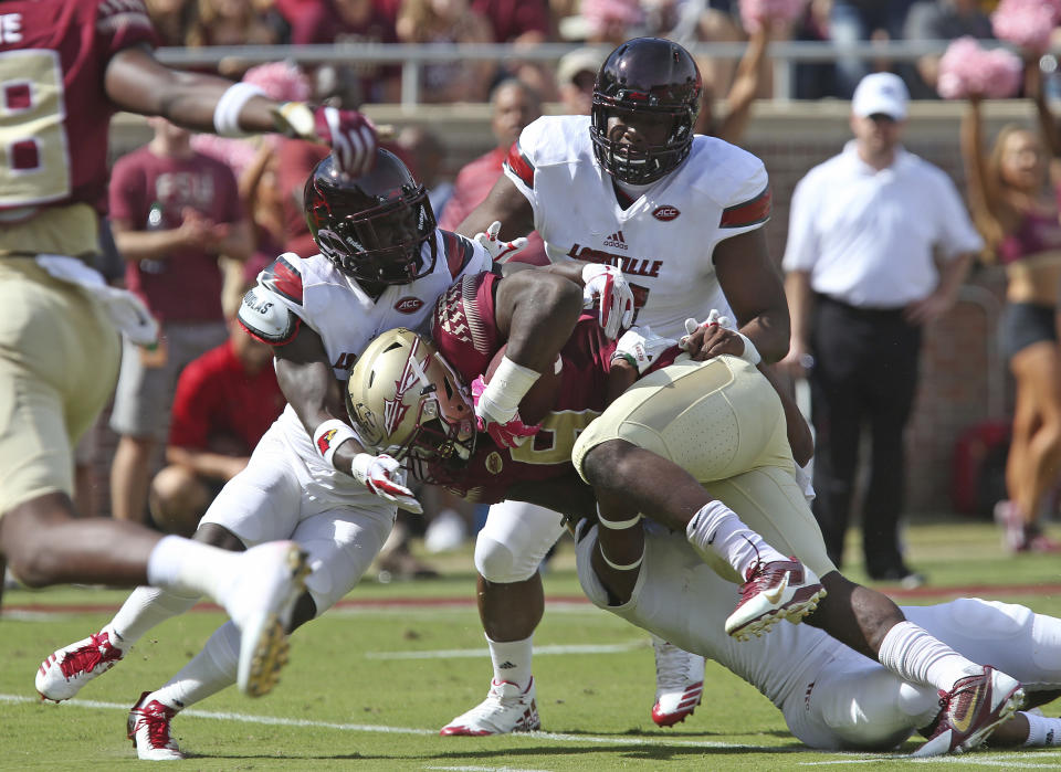 Florida State’s Jacques Patrick is tackled by a trio of Louisville defenders during an NCAA college football game, Saturday, Oct. 21, 2017, in Tallahassee Fla. Louisville won 31-28. (AP Photo/Steve Cannon)