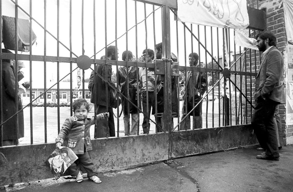 FILE - In this Nov. 6, 1979 file photo, an Iranian child holds a photo showing Ayatollah Ruhollah Khomeini in front of the entrance of the U.S. Embassy on the third day of the occupation of the building by Iranian students. Forty years ago on Nov. 4, 1979, Iranian students overran guards to take over the U.S. Embassy in Tehran, starting a 444-day hostage crisis that transfixed America. (AP Photo, File)