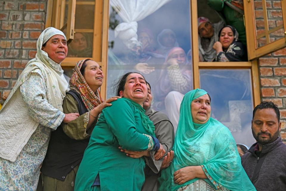 People mourn at the funeral of their relatives who died after a boat overturned in the Jhelum river (AFP via Getty Images)