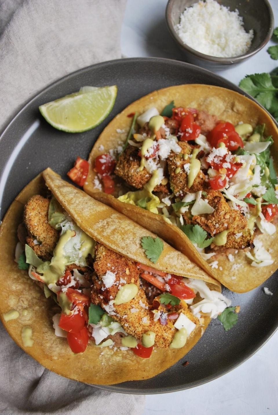 Two tacos filled with avocado "fries", slaw, and veggies.