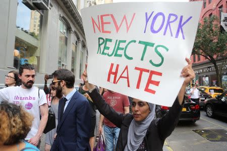 A protester holds a sign against U.S. President Donald Trump's limited travel ban, approved by the U.S. Supreme Court, in New York City, U.S., June 29, 2017. REUTERS/Joe Penney