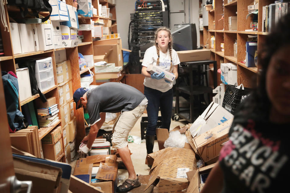 Volunteers and students from C.E. King High School help to clean up the school.