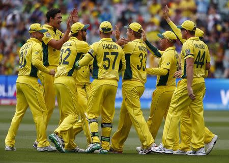 Australian bowler Mitchell Starc (2nd L) celebrates with team mates including Shane Watson (33) who caught out Pakistan's batsman Sarfraz Ahmed during their Cricket World Cup quarter final match in Adelaide, March 20, 2015. REUTERS/David Gray