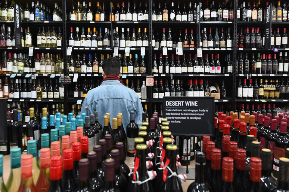 A patron stands in front of a shelf full of wine bottles at The Liquor Store.Com on March 20, 2020 in the Brooklyn borough of New York. - Liquor sales have exploded in New York since a national emergency was declared and New York closed all its theatres, bars and restaurants, while virtual cocktail parties with "quarantinis" are on the rise. (Photo by Angela Weiss / AFP) (Photo by ANGELA WEISS/AFP via Getty Images)