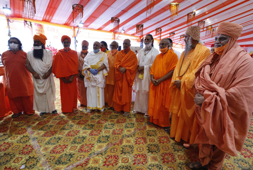 Hindu priests gather for a groundbreaking ceremony of a temple dedicated to the Hindu god Ram in Ayodhya, India, Wednesday, Aug. 5, 2020. The coronavirus is restricting a large crowd, but Hindus were joyful before Prime Minister Narendra Modi breaks ground Wednesday on a long-awaited temple of their most revered god Ram at the site of a demolished 16th century mosque in northern India. (AP Photo/Rajesh Kumar Singh)