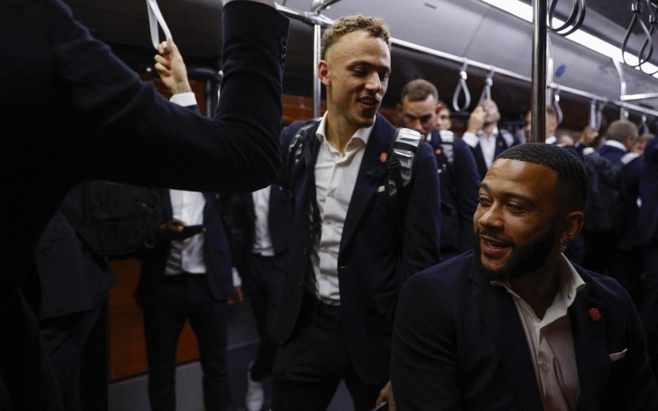 Noa Lang and Memphis Depay of Netherlands interact on from the airport bus upon arrival ahead of the FIFA World Cup Qatar 2022 at Hamad International Airport Special Events Terminal on November 15, 2022 in Doha, Qatar - Sarah Stier - FIFA/FIFA via Getty Images