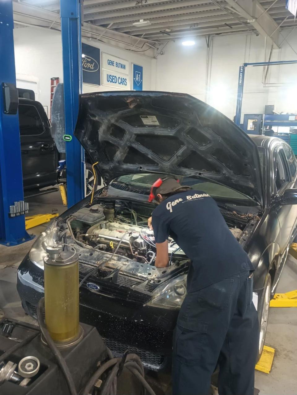 Dylan Spencer, 18, of Ypsilanti is seen here repairing at car at Gene Butman Ford in Ypsilanti on Monday, July 1, 2024. "I'm bleeding the clutch on a 2004 Ford Focus SVT."