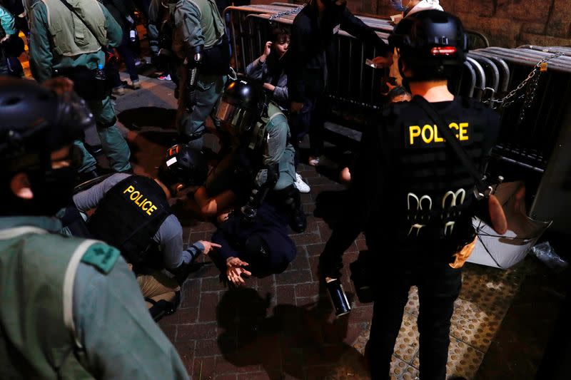 Riot police officers detain an anti-government protester during a demonstration on New Year's Eve outside Mong Kok police station in Hong Kong
