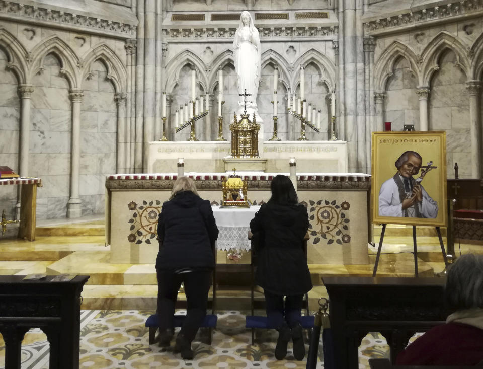 Two women pray in front a container bearing the heart of St. John Vianney Saturday, April 6, 2019 at St. Patrick's Cathedral in New York. The 150-year-old heart of the French priest is being toured throughout the United States. The tradition of venerating the body parts of saintly Catholics goes back to the Middle Ages in Italy. (AP Photo/Julie Walker)