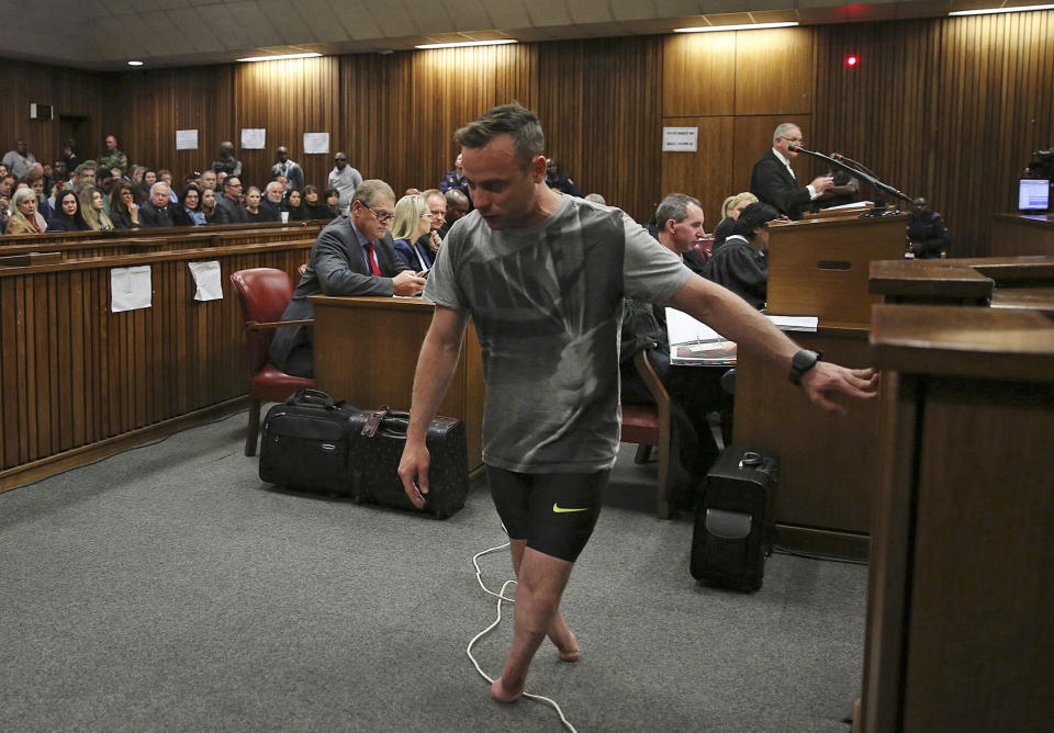 FILE — Oscar Pistorius, walks on his stumps during argument in mitigation of sentence by his defense attorney Barry Roux in the High Court in Pretoria, South Africa, Wednesday, June 15, 2016. An appeals court found Pistorius guilty of murder and not a lesser charge of culpable homicide for the shooting death of his girlfriend Reeva Steenkamp. Pistorius shot his girlfriend Reeva Steenkamp more than a decade ago in a Valentine's Day killing that jolted the world and shattered the image of a sports superstar.(Siphiwe Sibeko, Pool Photo via AP/File)