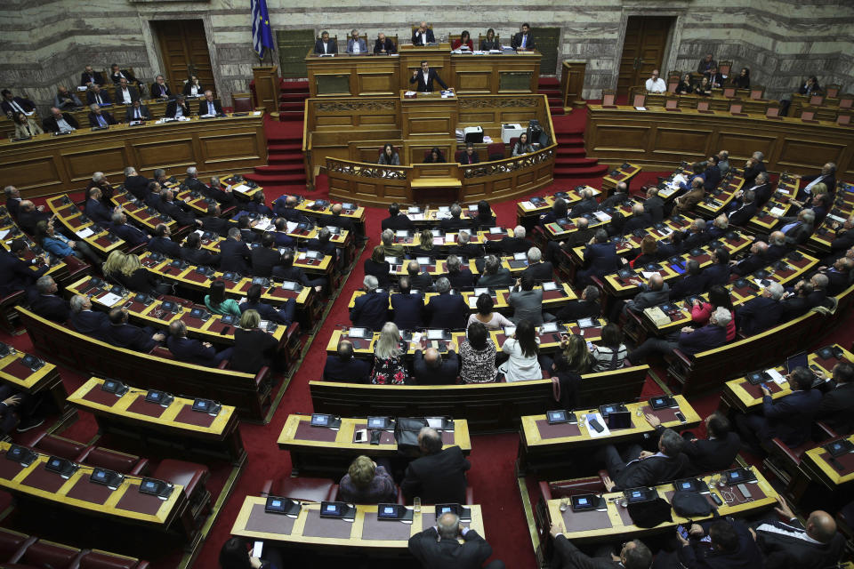 Lawmakers listens the speech of Greek Prime Minister Alexis Tsipras during a parliament session in Athens on Tuesday, Dec. 18, 2018. Greek lawmakers are debating the heavily-indebted country's draft budget for 2019, the first since Greece exited an eight-year bailout program. (AP Photo/Petros Giannakouris)