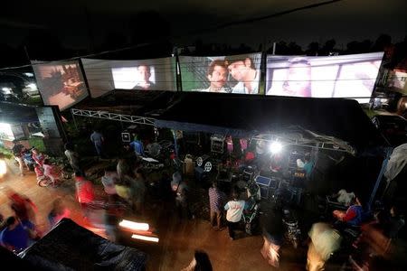 People watch films during a wedding party in Bogor, Indonesia, March 19, 2017. REUTERS/Beawiharta/Files