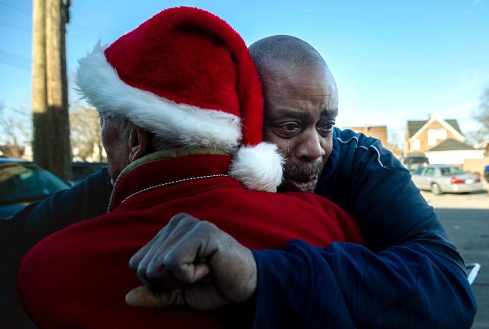 A Secret Santa elf hugs Brian Major after handing him a $100 bill in Lincoln Park on Thursday, Dec. 14, 2023. Major lost his mother recently, so this small act of kindness went a long way for him. The annual Secret Santa in Lincoln Park was spearheaded by a couple that wishes to remain anonymous with the help of the Lincoln Park Police Department to distribute money during the holiday season.