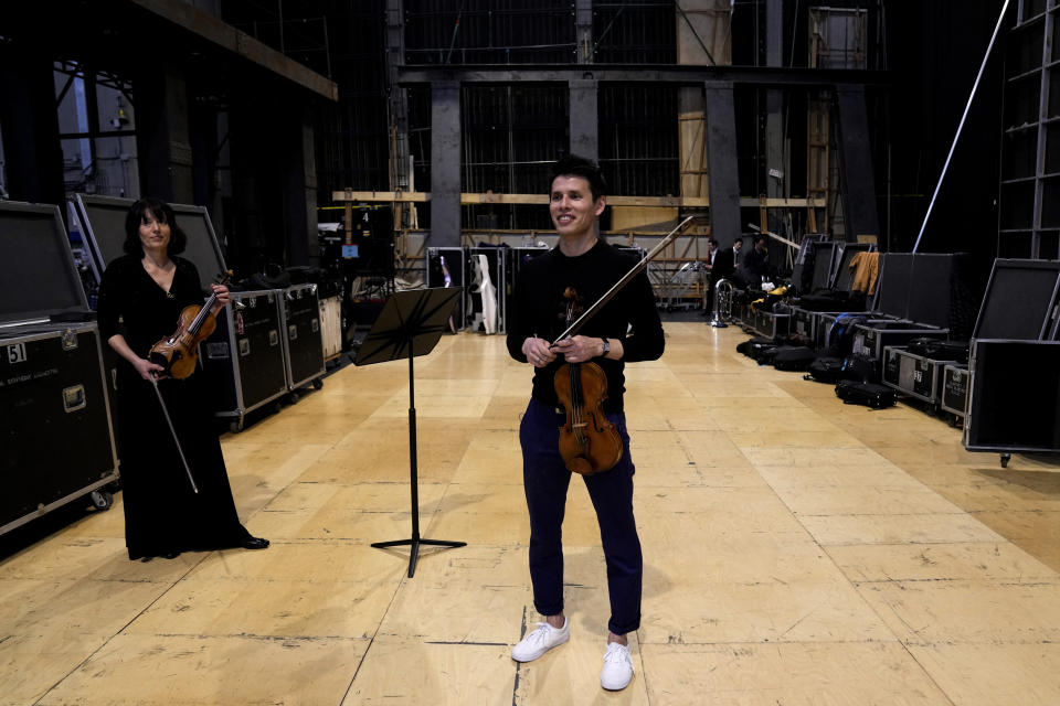 Violinist Derek Powell, right, and Principal Second Violin of the National Symphony Orchestra Marissa Regni backstage with two rare Italian stringed instruments from the 17th and 18th century used for the concert, during an interview with The Associated Press at Milan's La Scala theatre, Italy, Monday, Feb. 26, 2024. (AP Photo/Antonio Calanni)