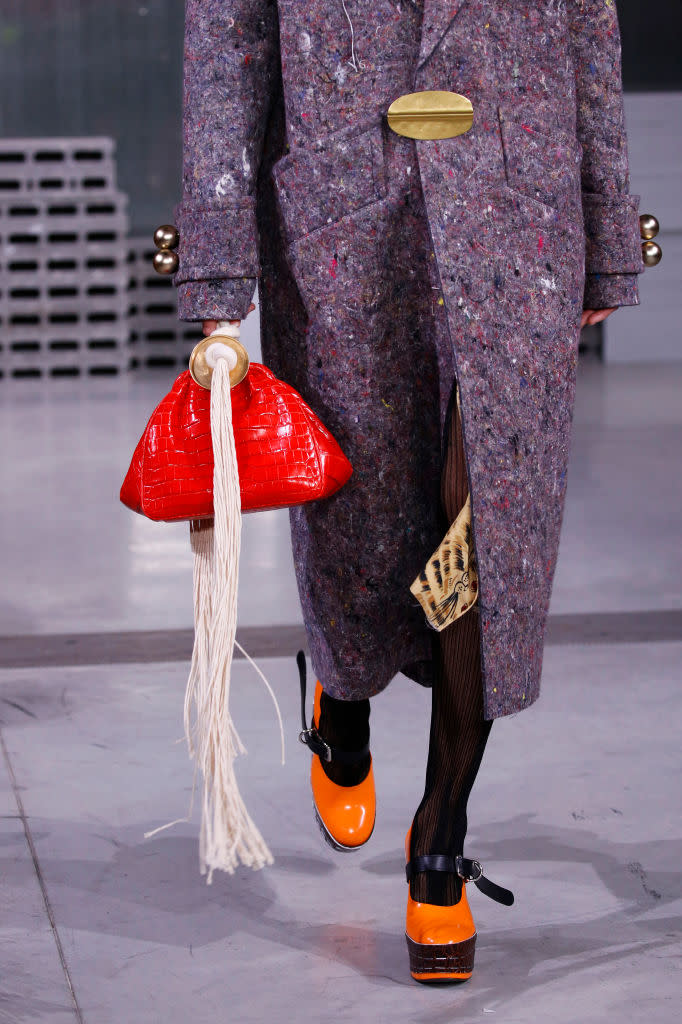 <p>A model carries a red pouch bag with fringe detail at the Marni FW18 show. (Photo: Getty Images) </p>